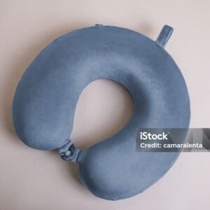 blue travel neck pillow made of fluffy fabric on a beige background